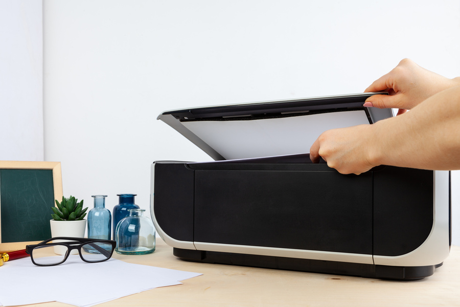 Une personne met du papier dans l'imprimante canon pixma pour vérifier si elle a bien vidé l'absorbeur d'encre