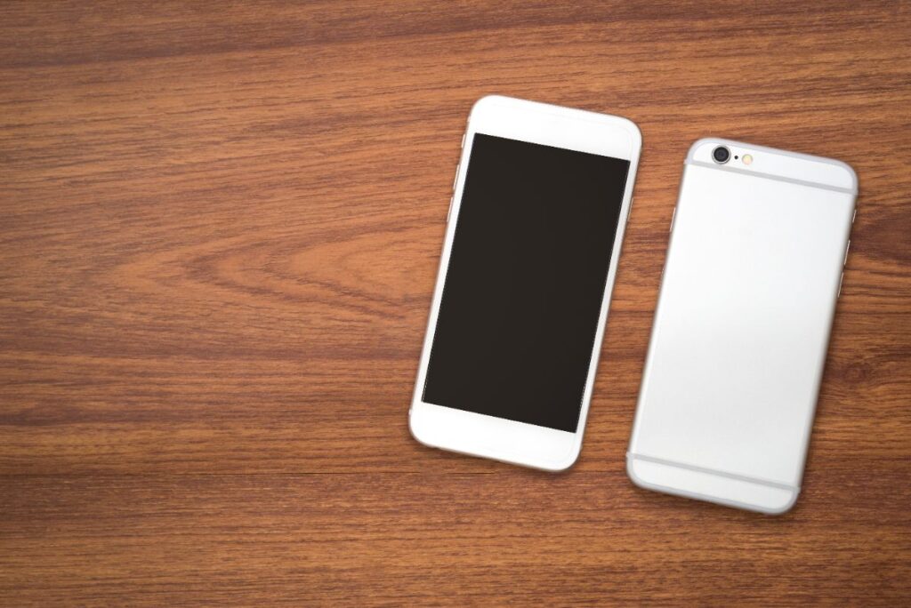 Une personne compare plusieurs modèles reconditionnés, chacun affichant une étiquette précisant la garantie incluse