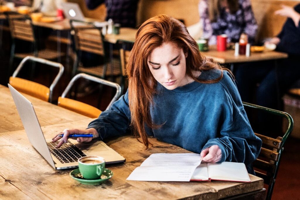Une femme concentrée à écrire un livre 
