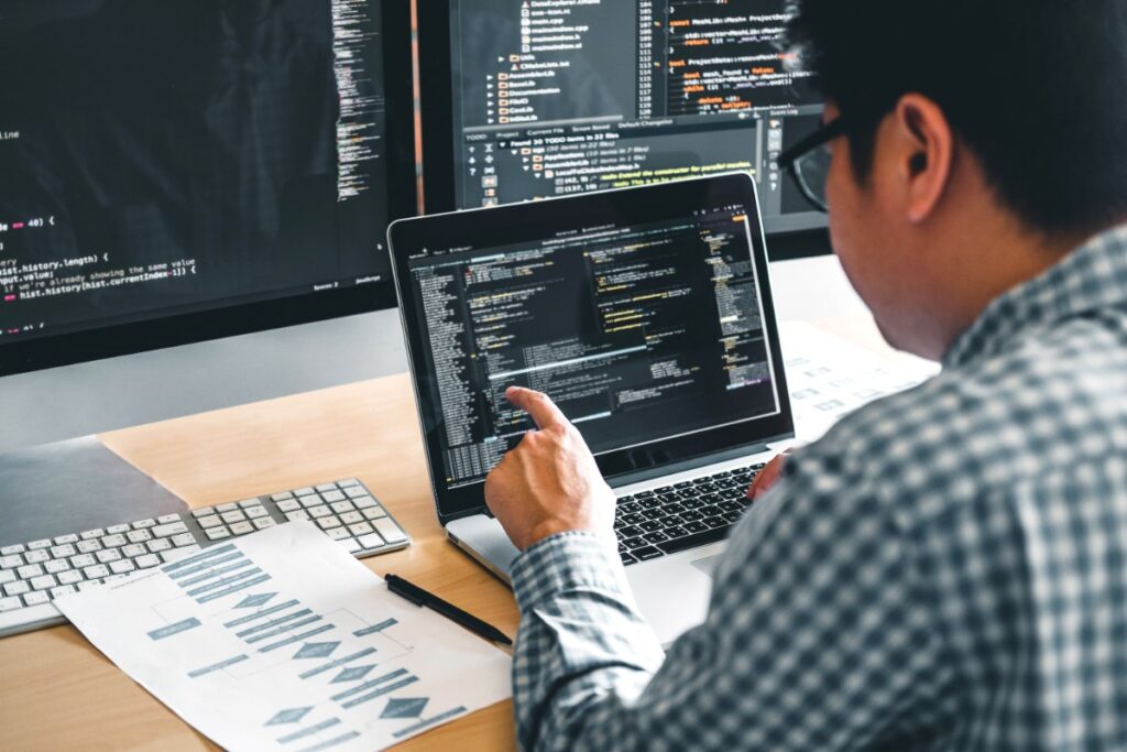 Un homme travaillant sur des ordinateurs pour créer un logiciel