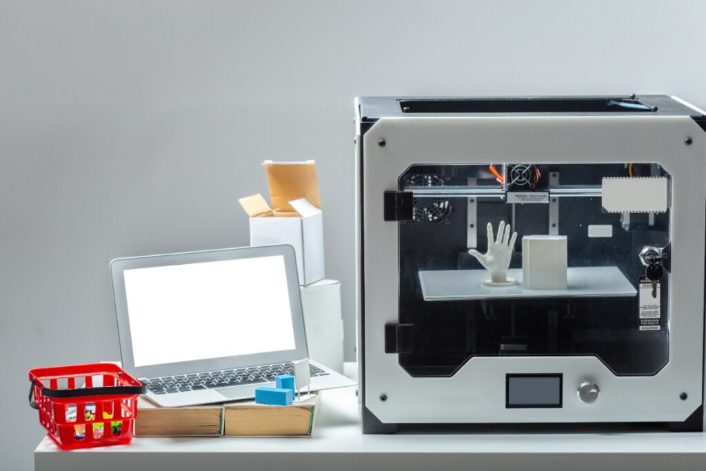 Un ordinateur et une imprimante 3D dans sur une table de bureau