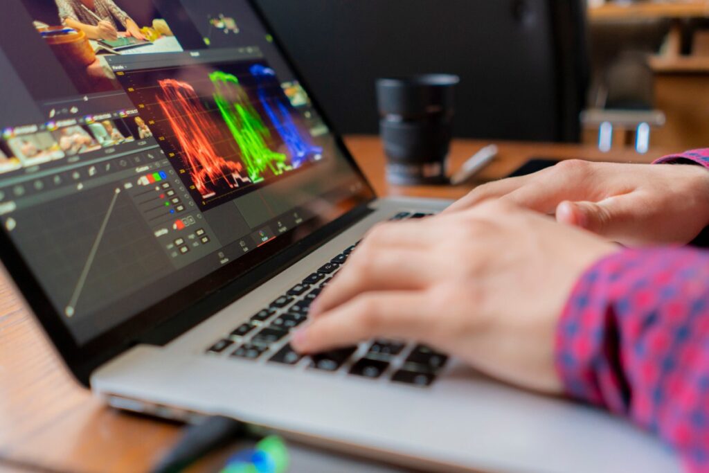 Une personne réalisant un montage vidéo avec des logiciels
