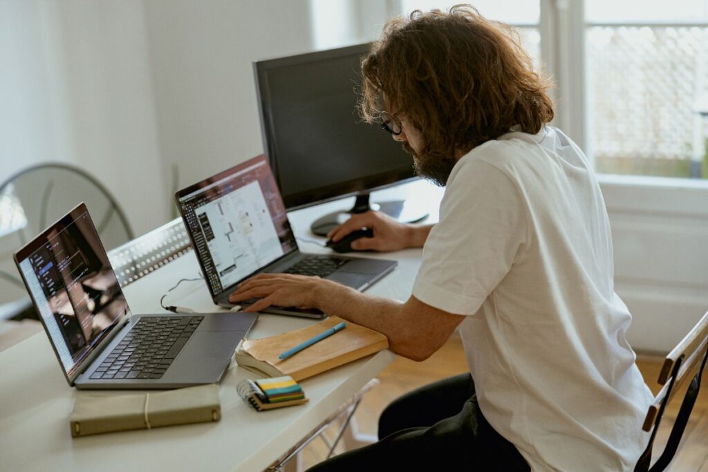 Un homme, assis dans son bureau, qui crée un site web sur WIX 