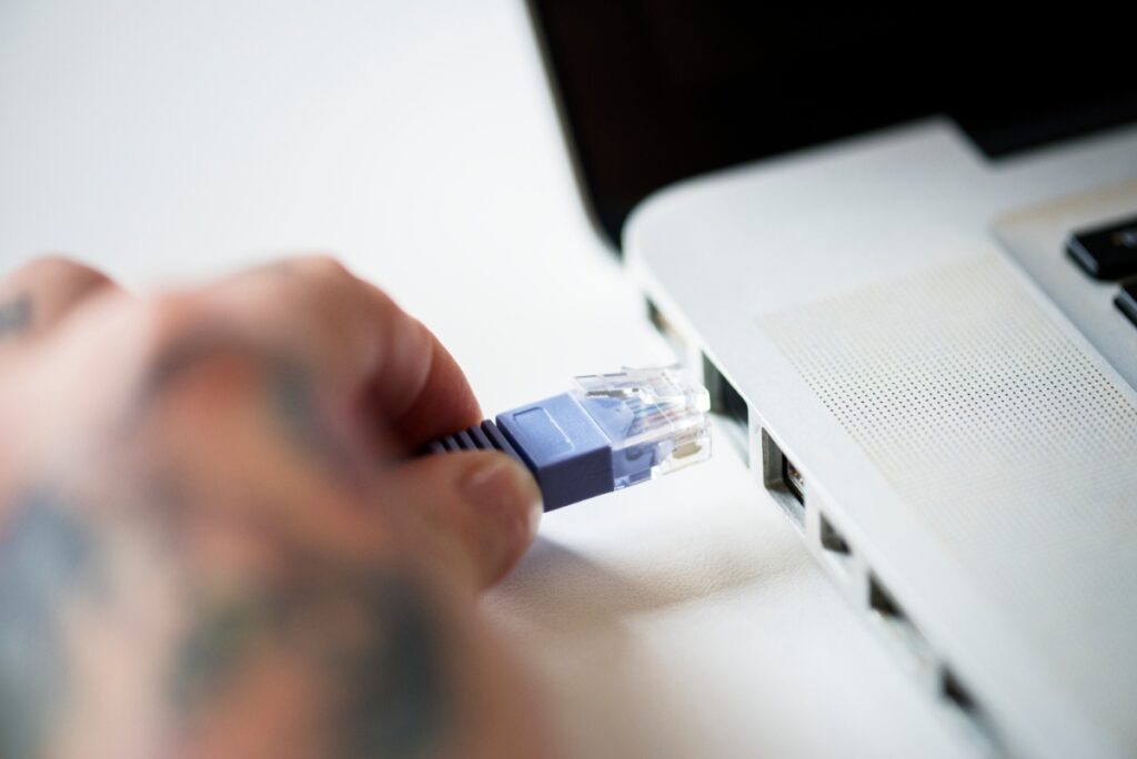Une personne faisant brancher un câble ethernet à un ordinateur