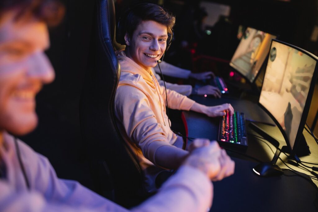 Un homme souriant en jouant à un jeu sur l'ordinateur