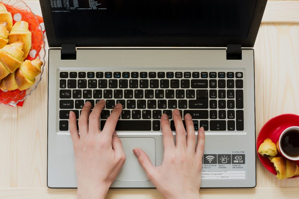 Des mains qui tapent sur le clavier d'un ordinateur portable Acer