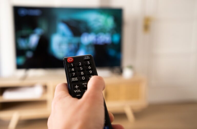 Une personne qui tient une télécommande