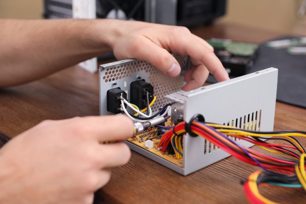 Mains d'un homme qui utilisent un outil pour réparer le pc