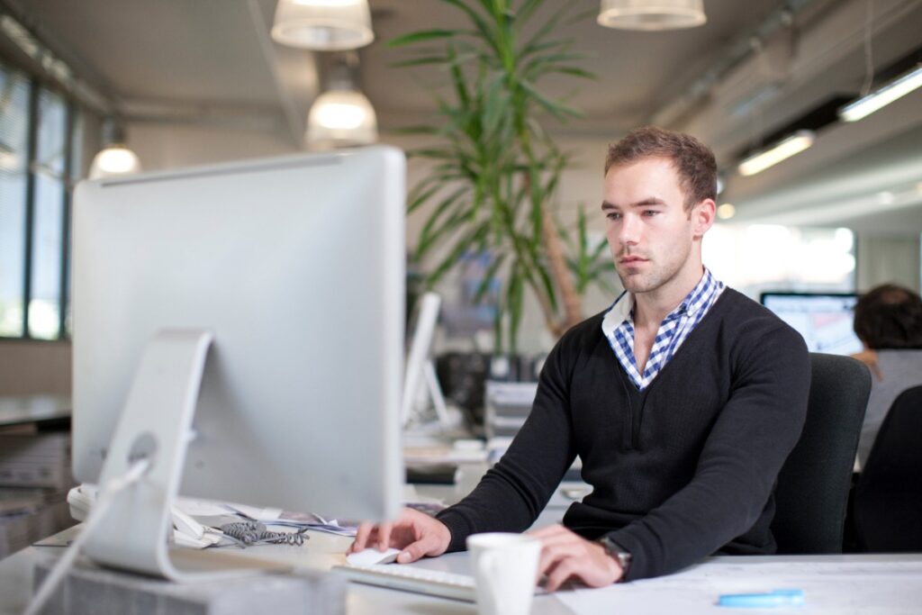Un homme assis dans son bureau devant un ordinateur