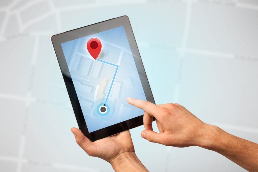 Mains tenant une tablette en suivant un itinéraire