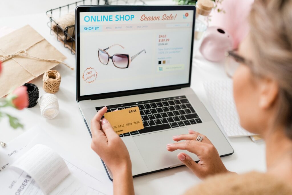 Une femme qui fait un achat en ligne sur un site e-commerce avec une carte à la main