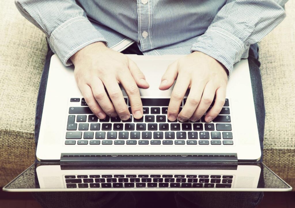 Mains tapant sur l'ordinateur portable