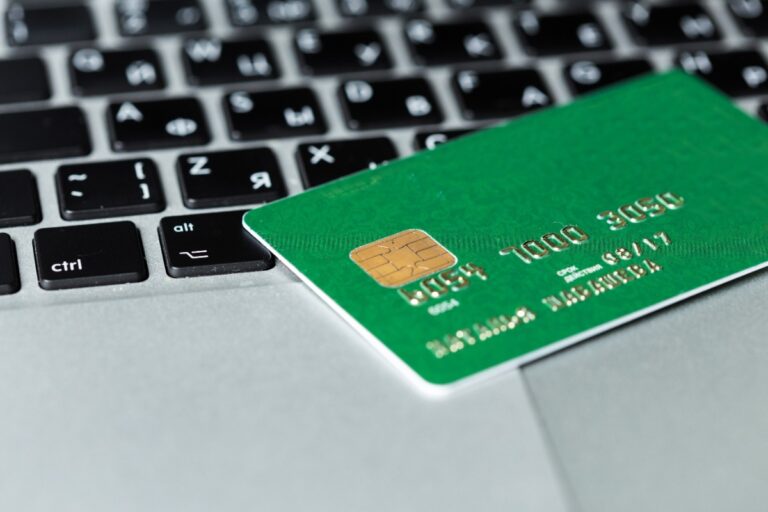 Une carte de crédit verte posée sur le clavier d'un ordinateur