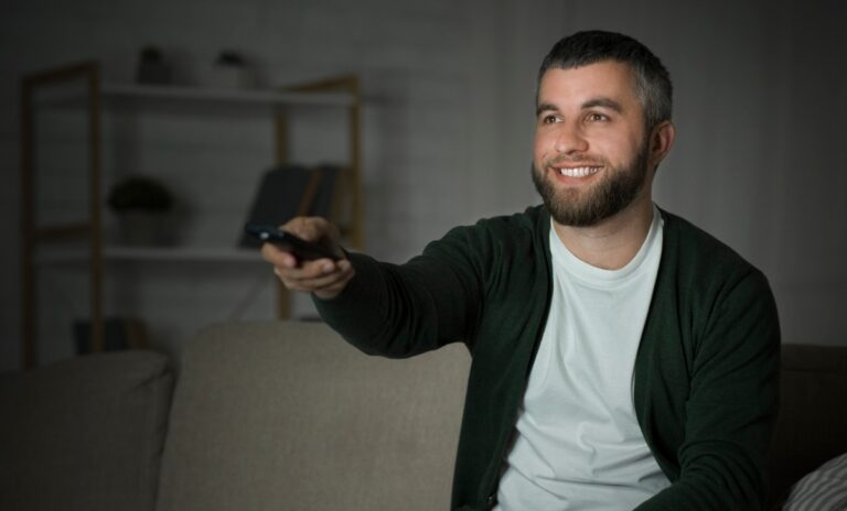 Un homme se relaxant avec une télécommande à la main