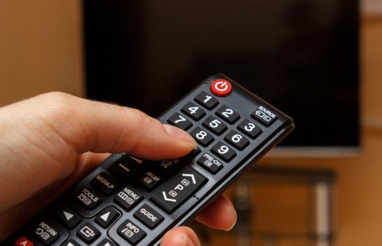 Main pointant la télécommande vers la télévision