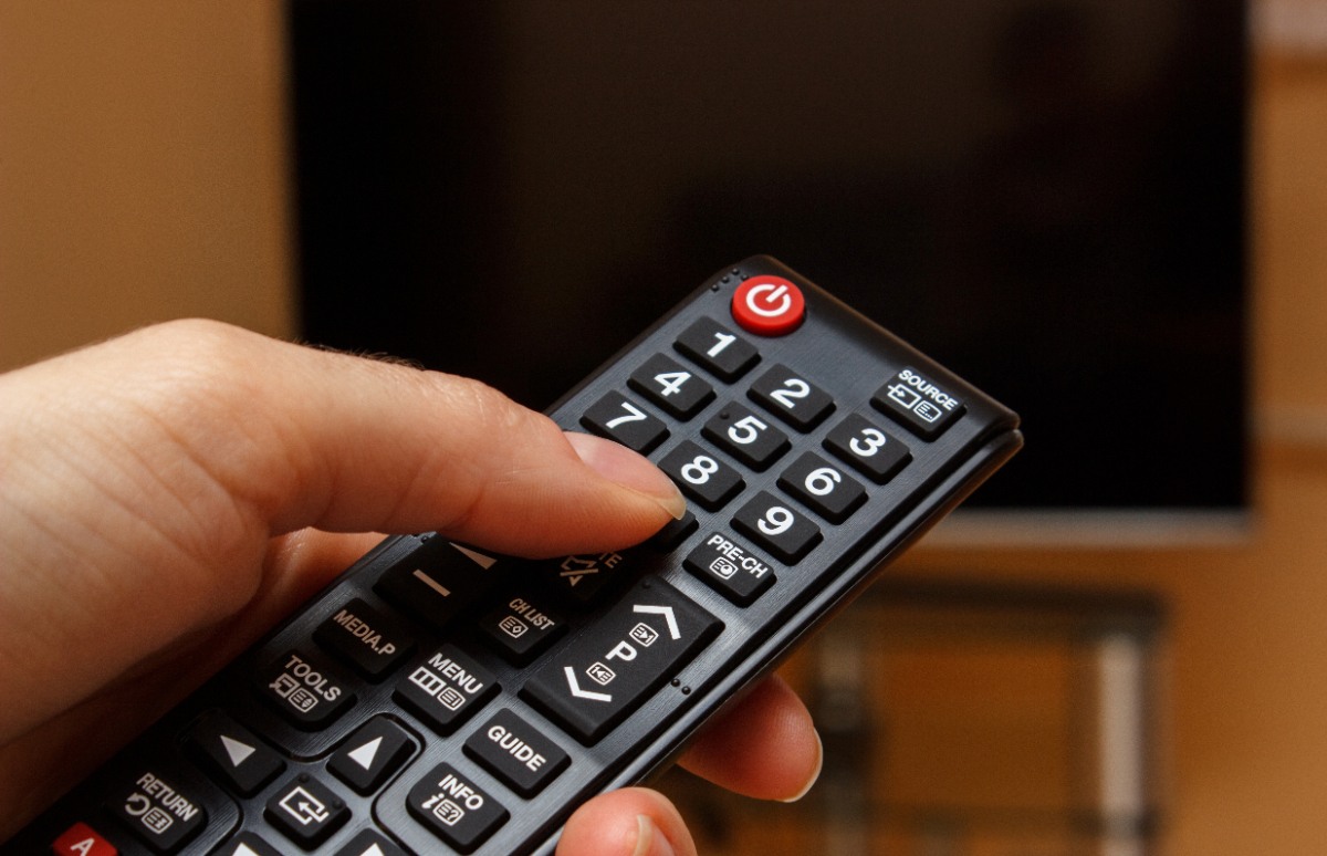 Main pointant la télécommande vers la télévision