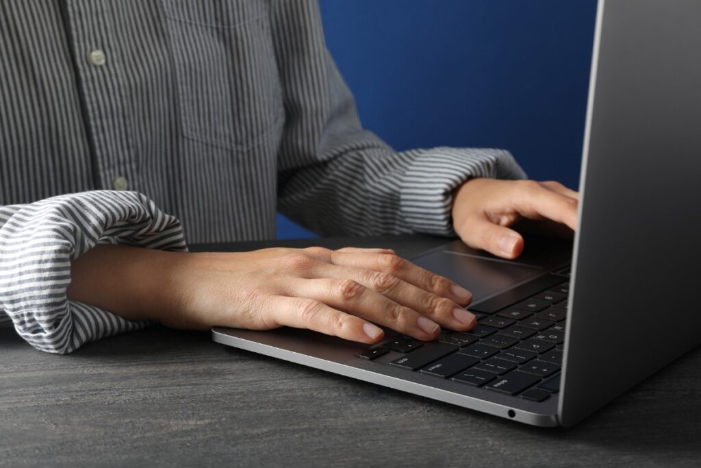 Mains sur le clavier d'un ordinateur portable